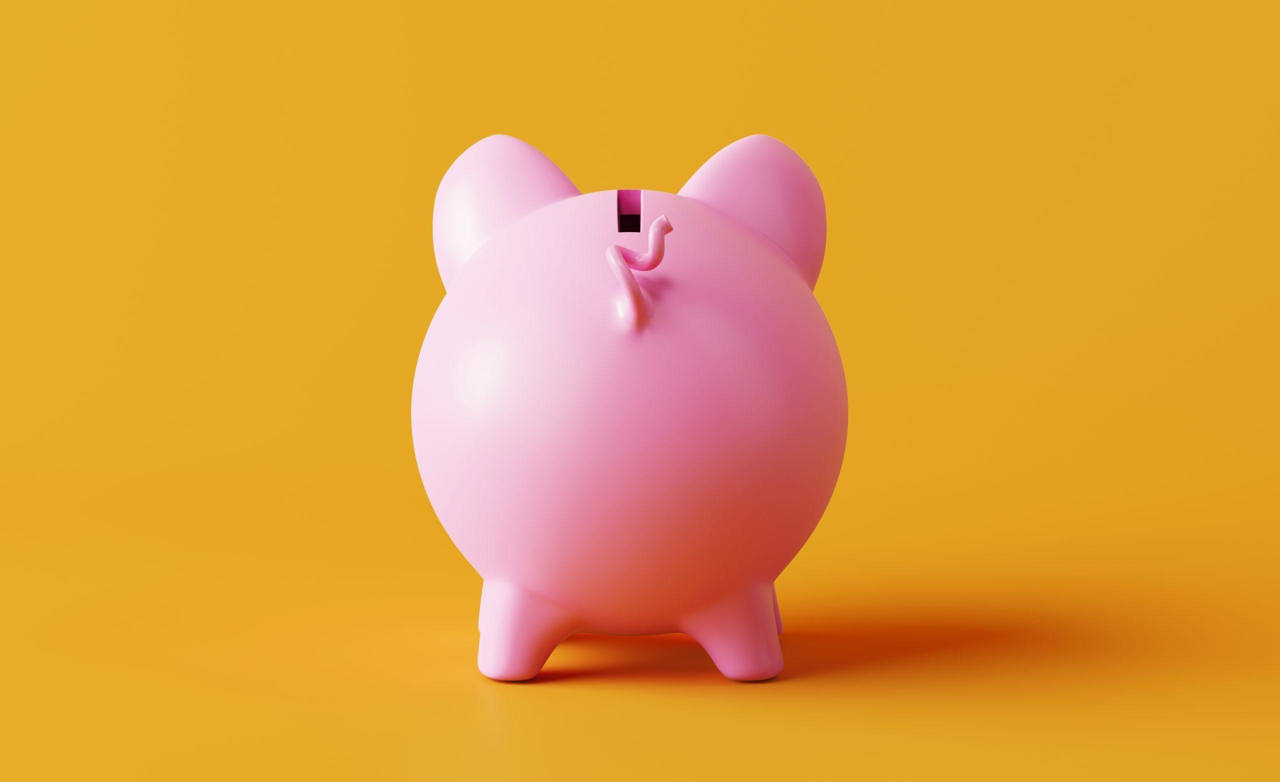 Piggy bank standing on yellow background. Horizontal composition with copy space. Great use for savings concepts.
